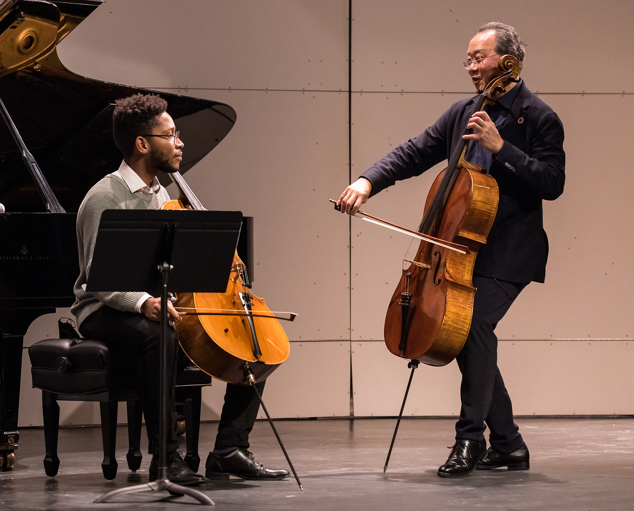 UCSB student Ivan Law taking instruction from Yo-Yo Ma on stage during a masterclass