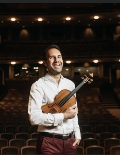 Pasha Sabouri holding violin in theatre